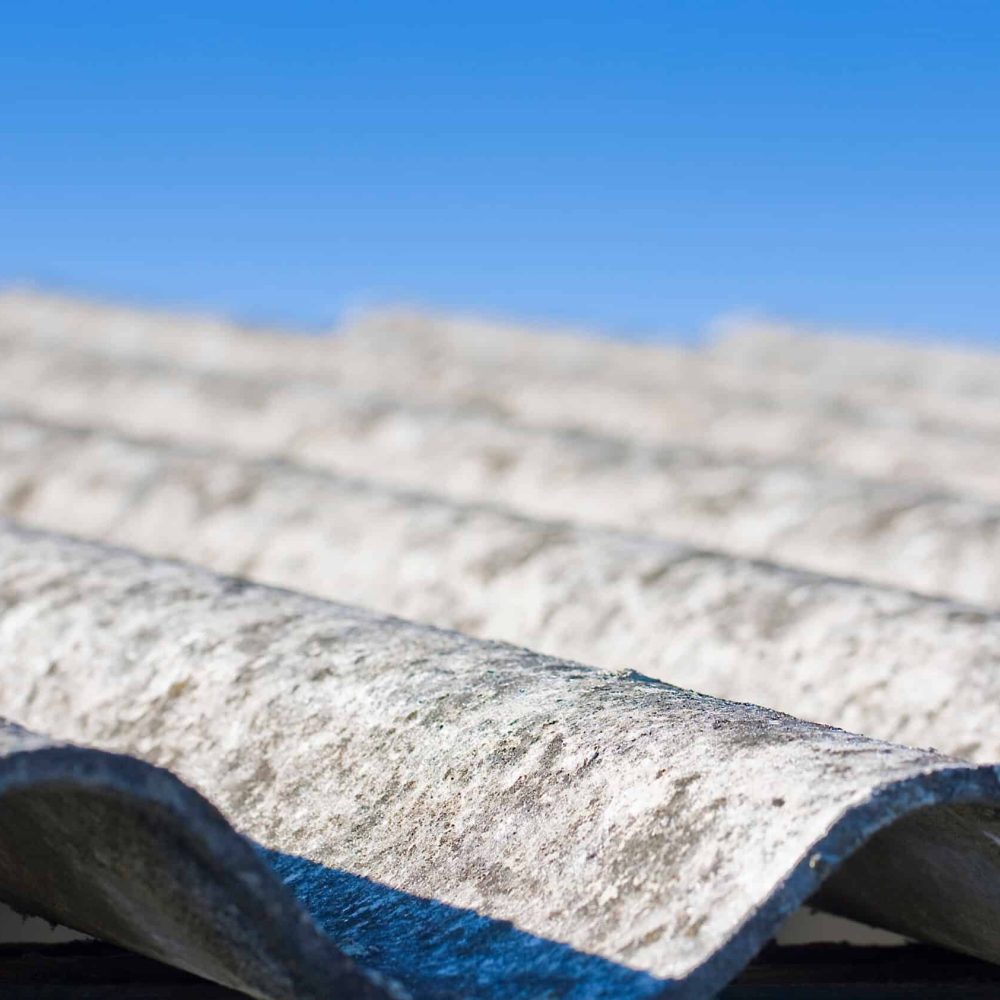 Old aged dangerous roof made of corrugated asbestos panels - one of the most dangerous materials in buildings and construction industry so-called hidden killer.